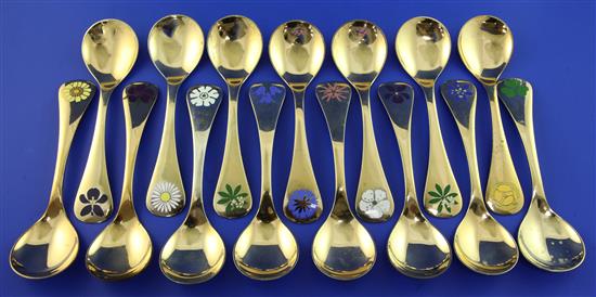 Fourteen Georg Jensen silver gilt and enamel annual spoons, gross 22 oz.